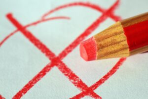 Red pencil marking an X for an election
